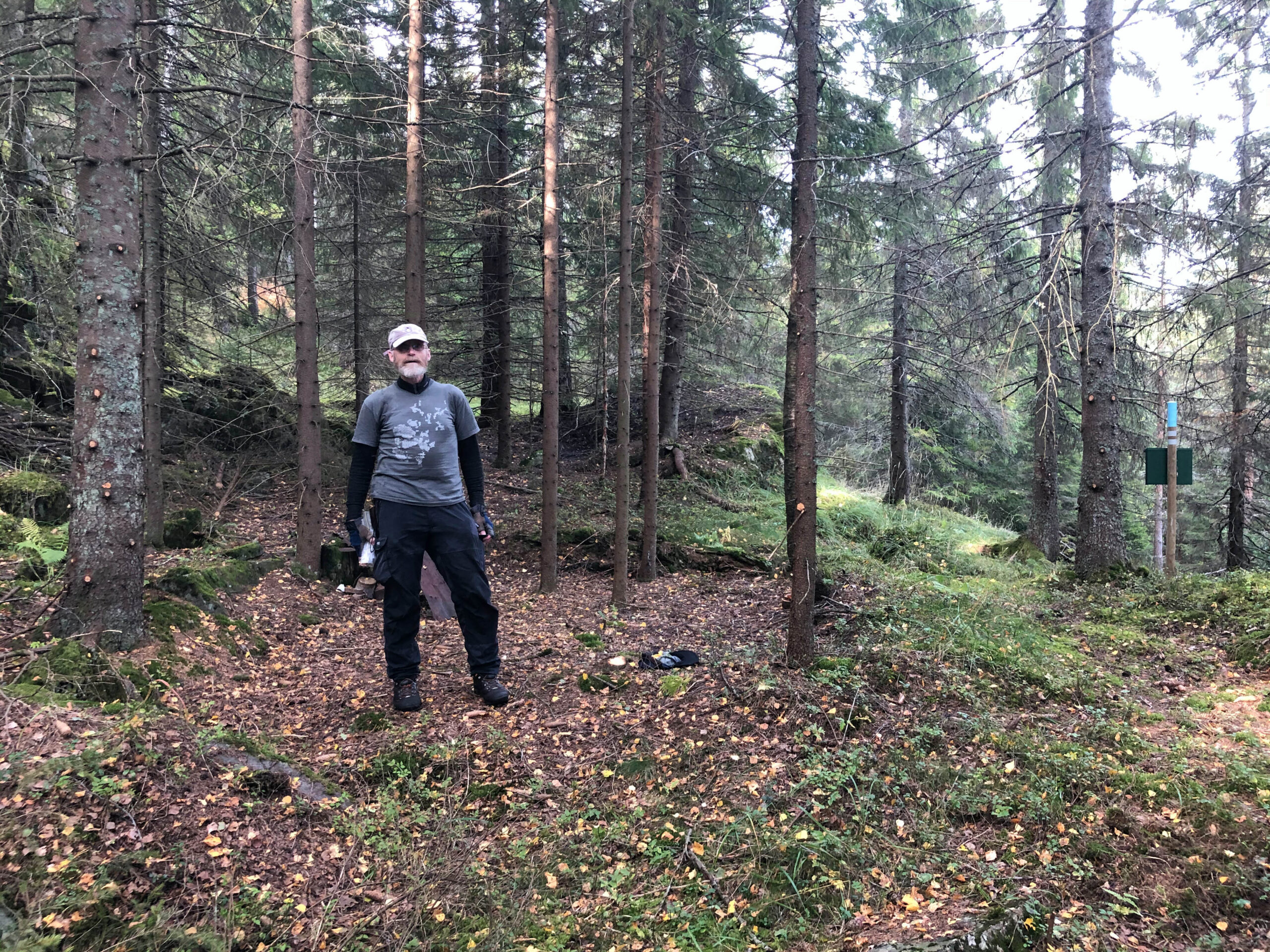 Bjønnebete i 2020. Man kan tydelig se forsenkningen i terrenget der koia stod. Se også rester av blikkbokser, mm. bak personen. Foto: Lars Rogstad