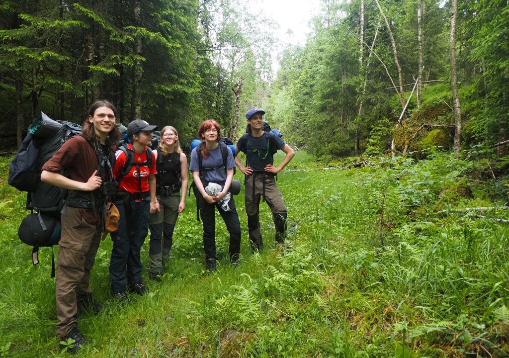 De fem Natur og Ungdom-medlemmene støtter ØVs protest mot byggingen av Dammyrveien. Her står de i den planlagte veitraseen gjennom Deledalen – hvor Losby Bruk AS ønsker å frakte tømmer på opptil 24 meter lange vogntog. Fra venstre: Storm Lillebø Gambert, Eira Børresen Ryste, Erika Andersen Gjedebo, Maja Holstad og Jesper Stattin. Foto: Bjarne Røsjø.