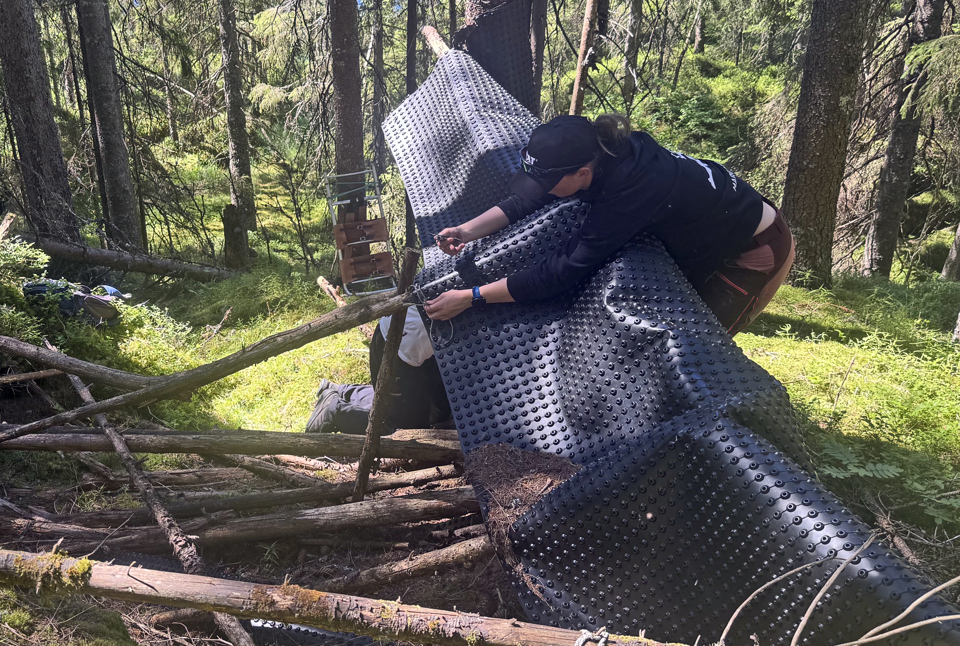 Henrik Røst Solberg og Margrethe Engenes Birkeland kjemper med å ta ned og pakke sammen ei gammel og forfallen knotteplasthytta ved Høgkolltjern. Restene ble tatt ned og båret ut til skiløypa ved østenden av Søndre Krokvann, der den ble lagret sammen med annet avfall, som kan hentes med snøscooter når vinteren kommer. Foto: Johan G. Ellingsen.